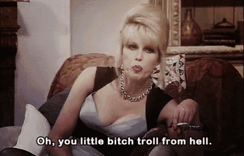 a woman is sitting on a couch smoking a cigarette and saying " oh you little bitch troll from hell "